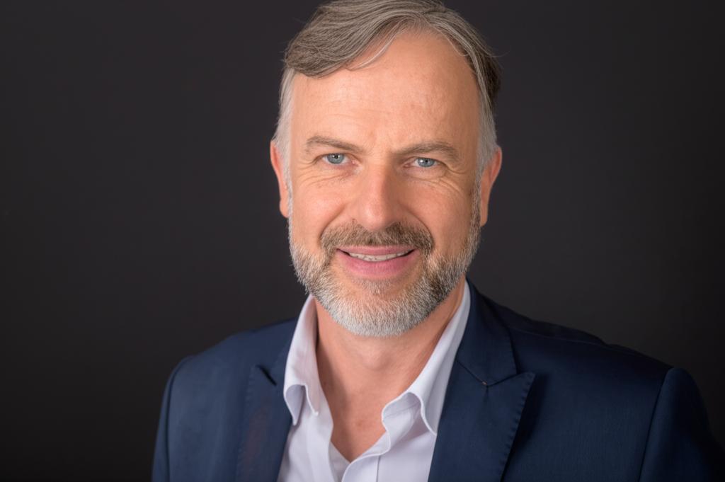 A middle-aged man looking relaxed and confident, perhaps with a subtle suggestion of happiness or vitality.
